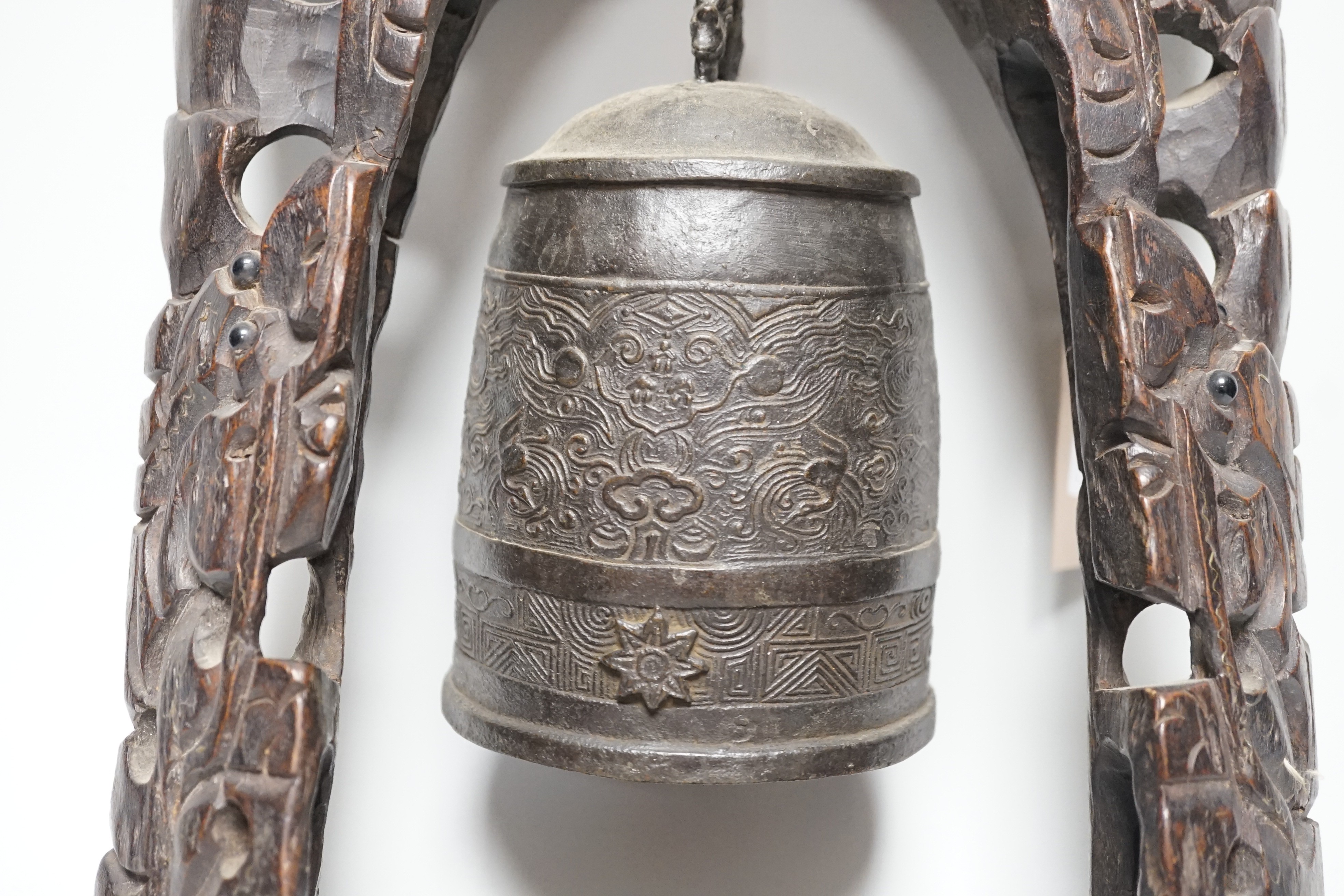 A Chinese bronze bell with wire inlaid carved hardwood stand, 44cm